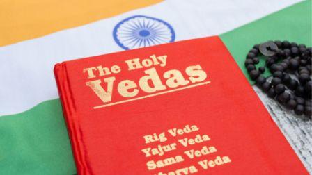 livre rouge des vedas, résumant les bases de l'ayurveda, posé sur le drapeau indien