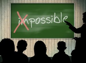 enseignant montrant à ses élèves qu'il y a le mot possible dans le mot impossible