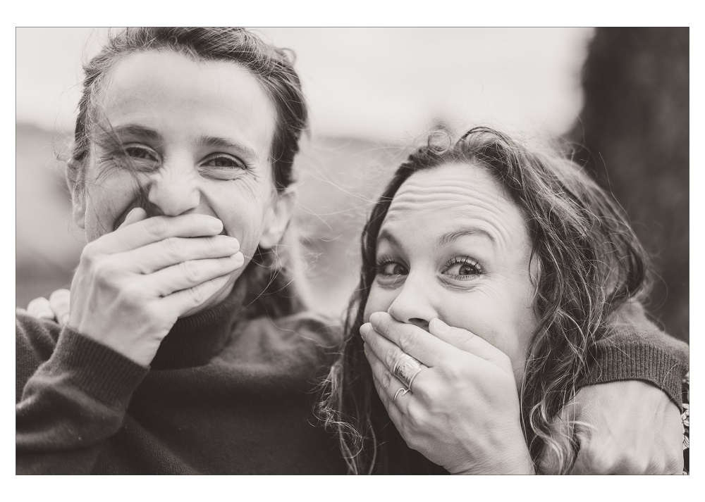 Deux femmes se cachent la bouche pour rire