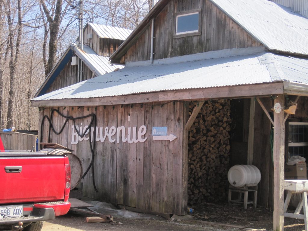 Un chalet en bois au Québec sur lequel est inscrit : "Bienvenue"