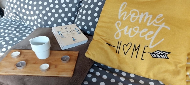 Ambiance Hygge : livre, tasse, bougies et coussin Home Sweet Home