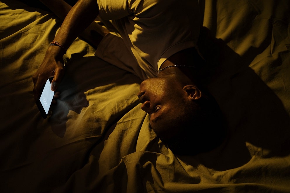 homme utilisant son téléphone dans son lit