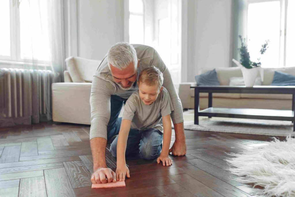 Utilisation du nettoyant multi-usage sur un parquet par un grand-père et son petit-fils