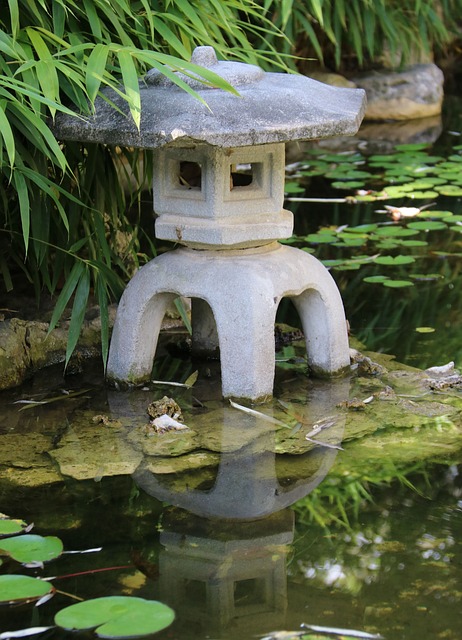 Lanterne traditionnelle japonaise en pierre nommée Toro et située au bord d'un bassin dans un jardin japonais