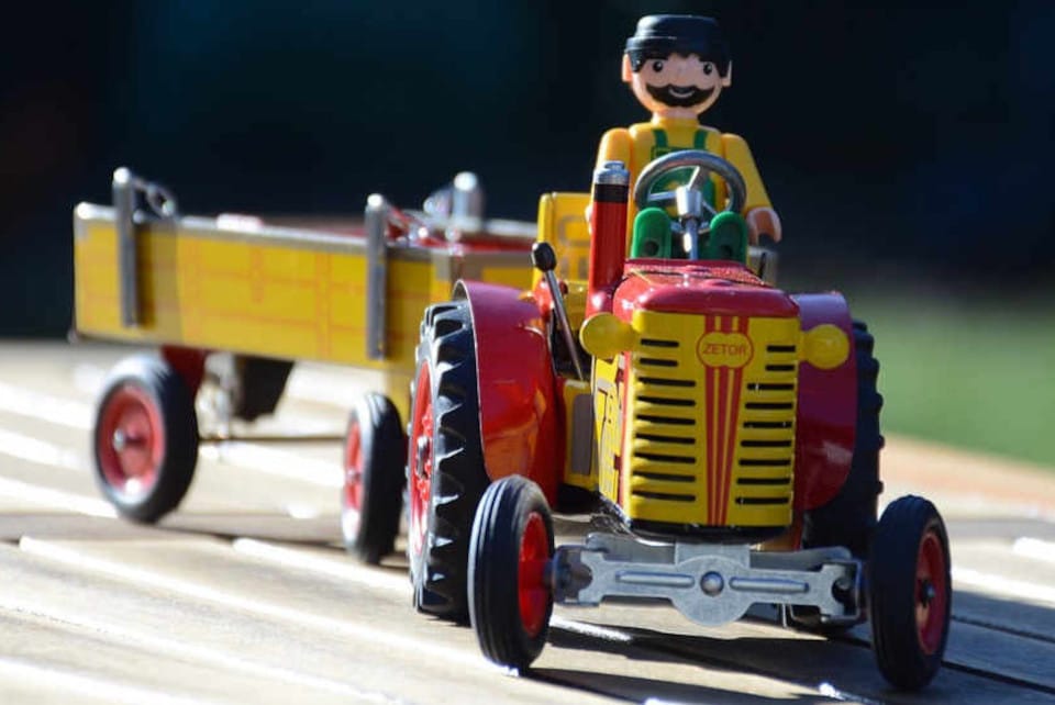 Une miniature de tracteur en métal rouge et jaune.