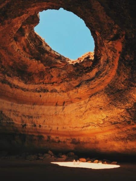 S'expatrier au Portugal en famille. Les Grottes Benagil en Algarve au Portugal Un couple se trouve assis au milieu de cette immense grotte