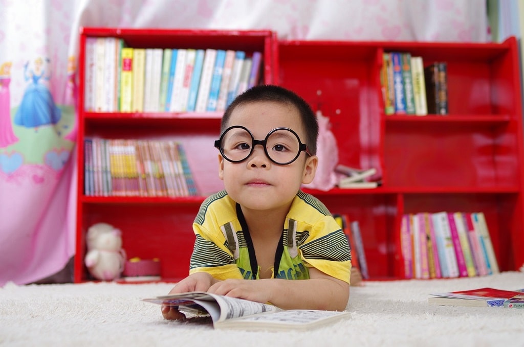 petit écolier à lunettes rondes qui apprend à lire