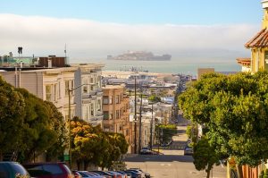 Rue en pente à San Francisco avec vue sur Alcatraz