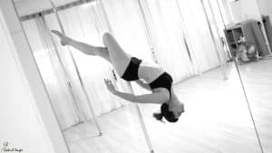 Entrainement d'une femme à la pratique de la pole dance en studio.