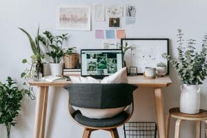 bureau à la maison confortable et personnalisé avec photos, plantes vertes, et notes sur le mur