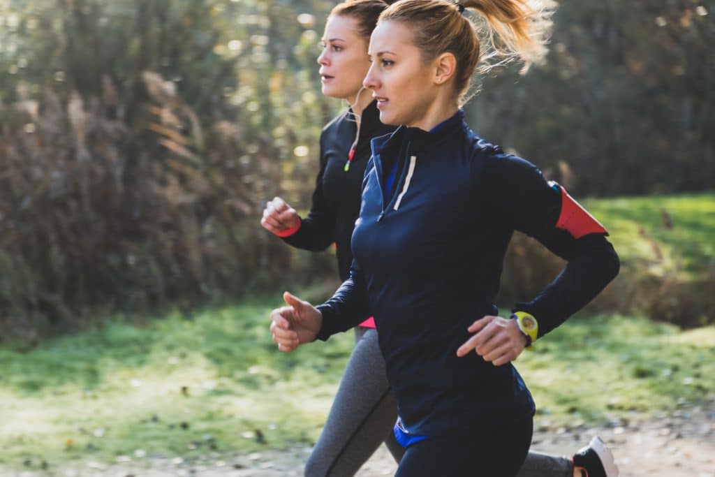 Joggeuses dans un parc qui s'entraînent à deux. 