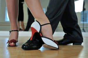 Chaussures de tango argentin. La femme porte des chaussures à talon et l'homme des souliers de danse noirs. 