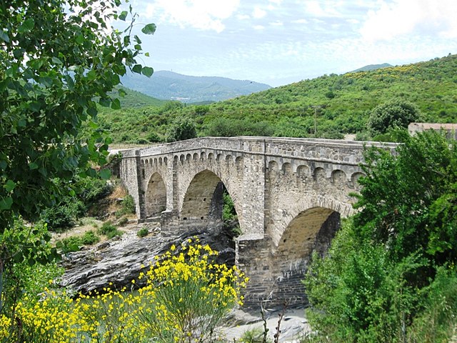 Le pont génois corse d'Altiani : ancien pont de pierre à trois arches, entouré de verdure