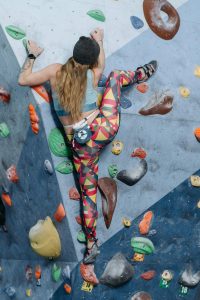 Une personne qui grimpe au mur d'escalade avec la pointe du pied.