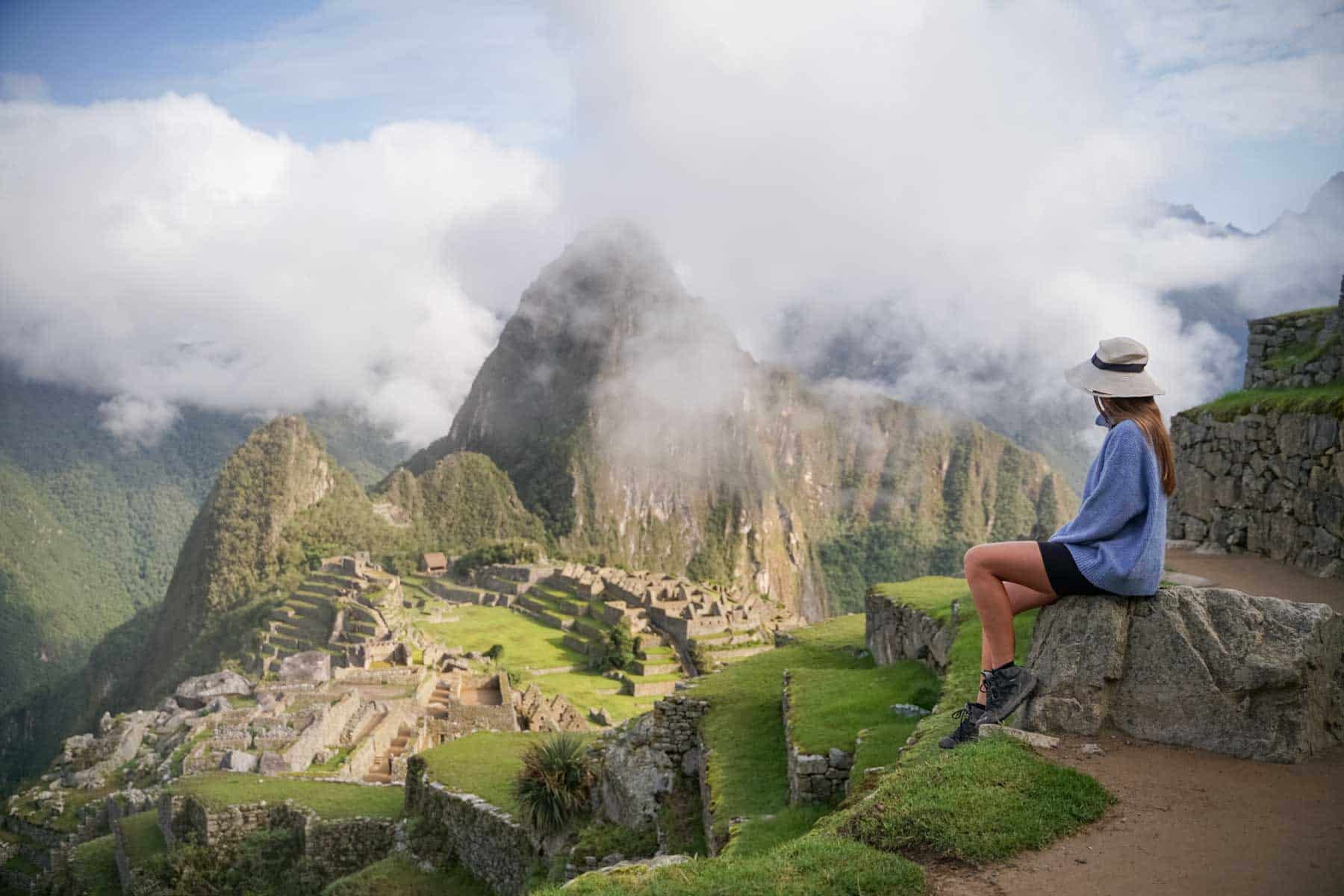 Une femme est assise en face du Machu Picchu au Pérou, après le trek du Salkantay.