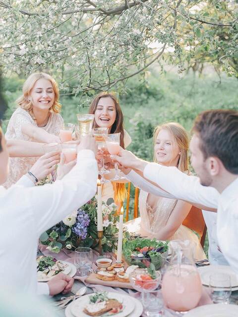 Groupe de personnes réunies autour d'un repas en extérieur