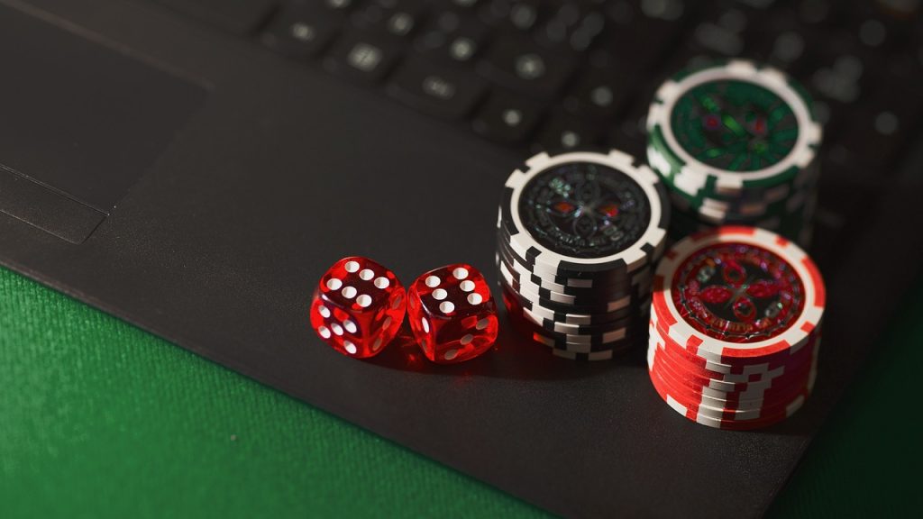 Apprendre le poker : dés et jetons sur un ordinateur illustrant le poker en ligne