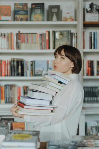 libraire portant une pile de livre